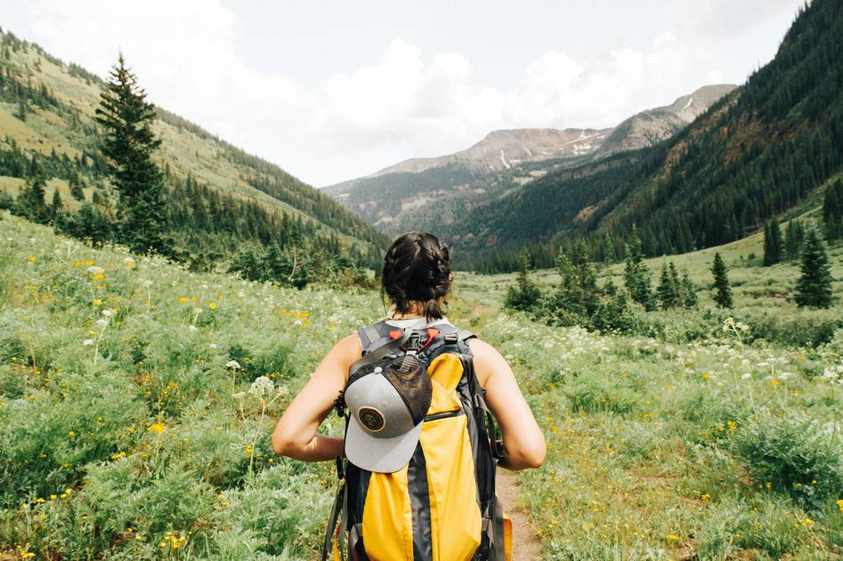 Bloggers reviewing compact hiking cameras beside alpine lake