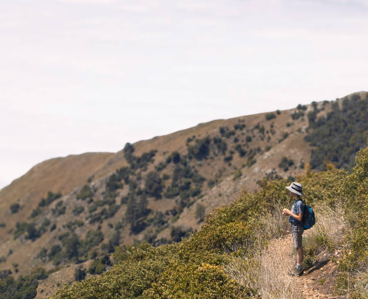 Adventure Video Editing Tips: hiker reviewing trail footage on laptop at campsite